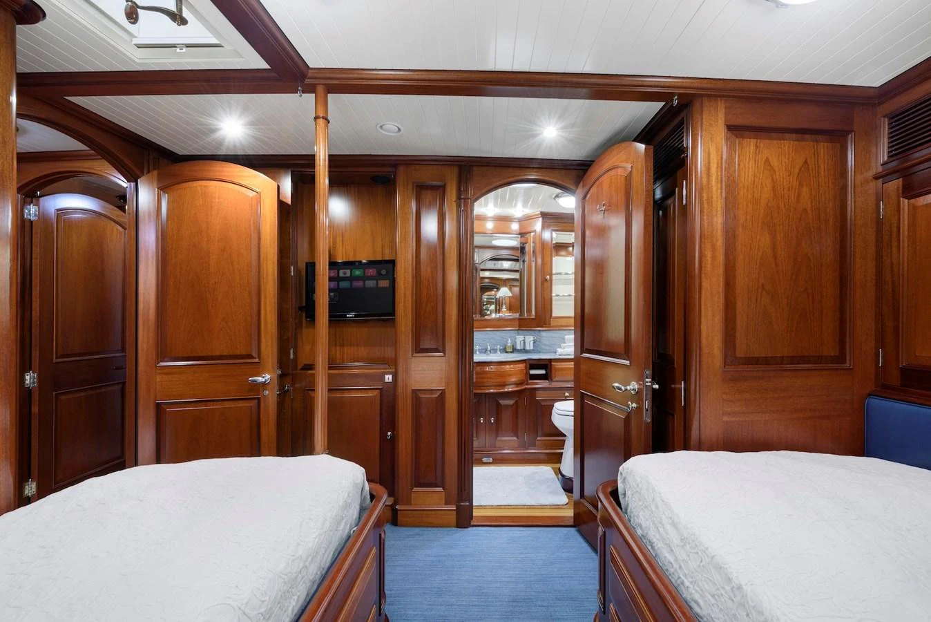 The guest stateroom features twin beds, rich wood paneling, and an ensuite bathroom. aboard METEOR Yacht for Sale