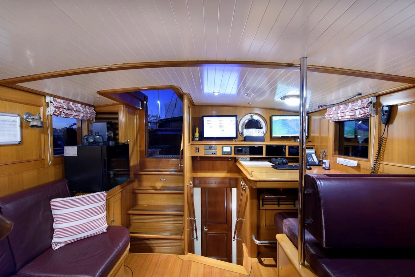 The yacht's helm features a cozy and well-equipped control area with wooden finishes and modern navigation instruments. aboard METEOR Yacht for Sale