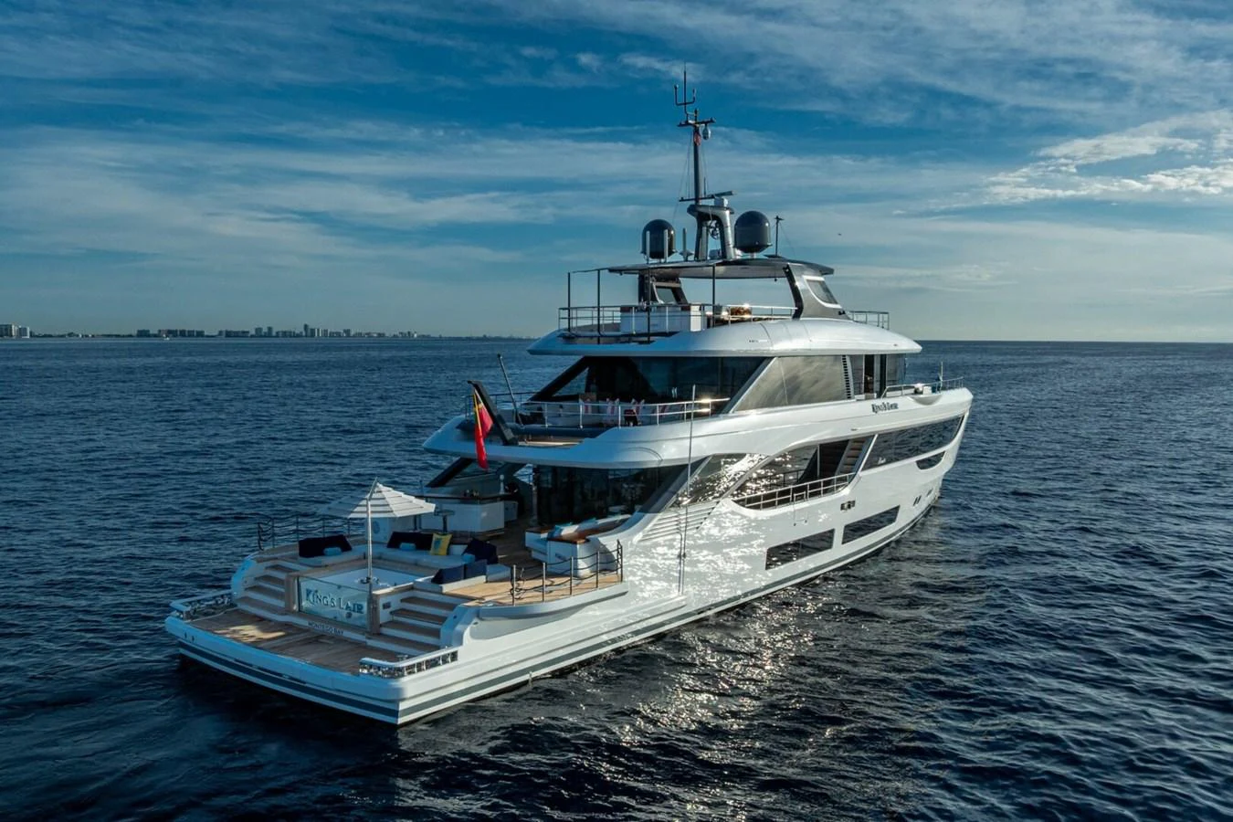 A stunning yacht cruises gracefully on the open water under a clear blue sky. aboard KING'S LAIR Yacht for Sale