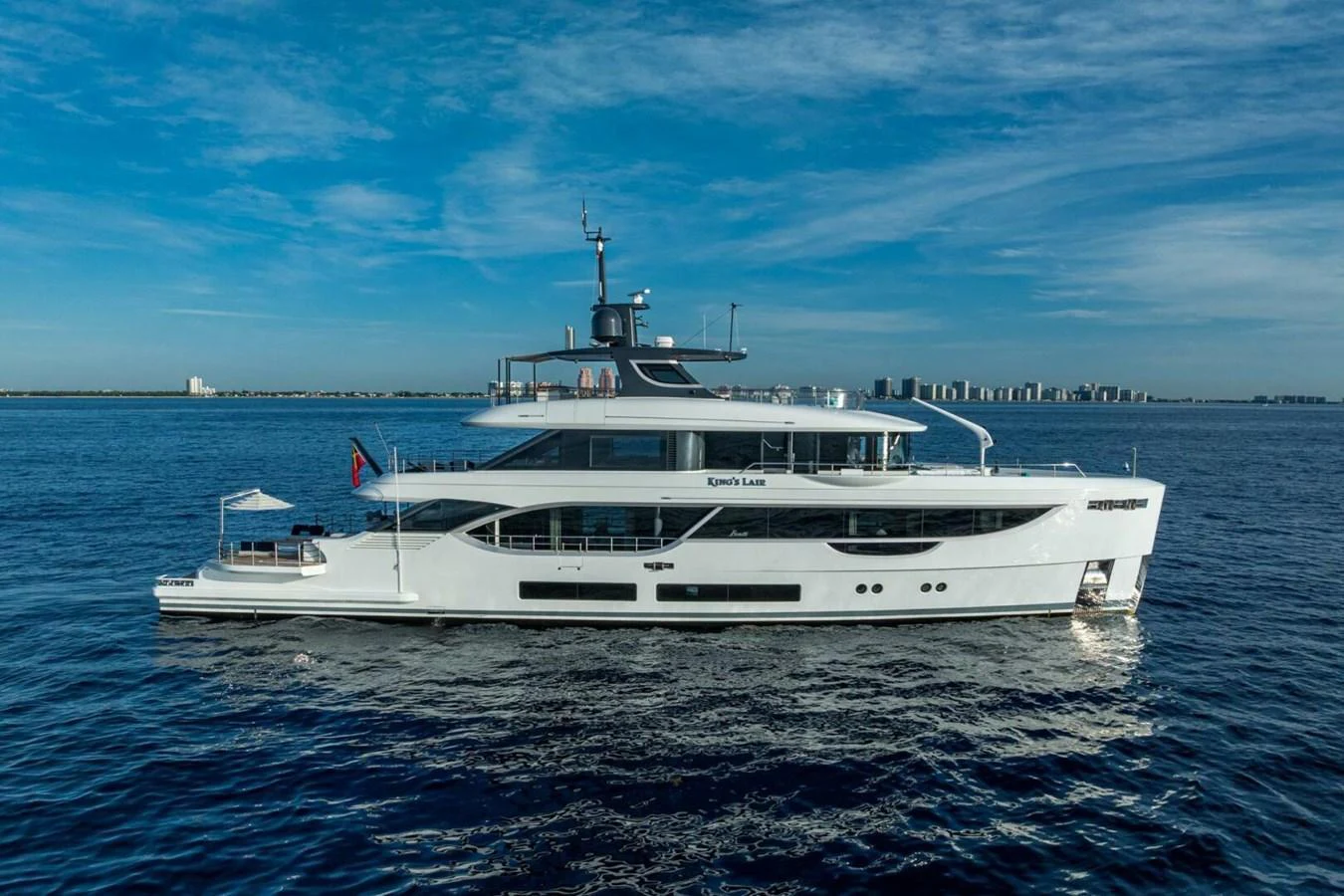 A sleek and modern yacht cruising on calm waters under a clear blue sky. aboard KING'S LAIR Yacht for Sale