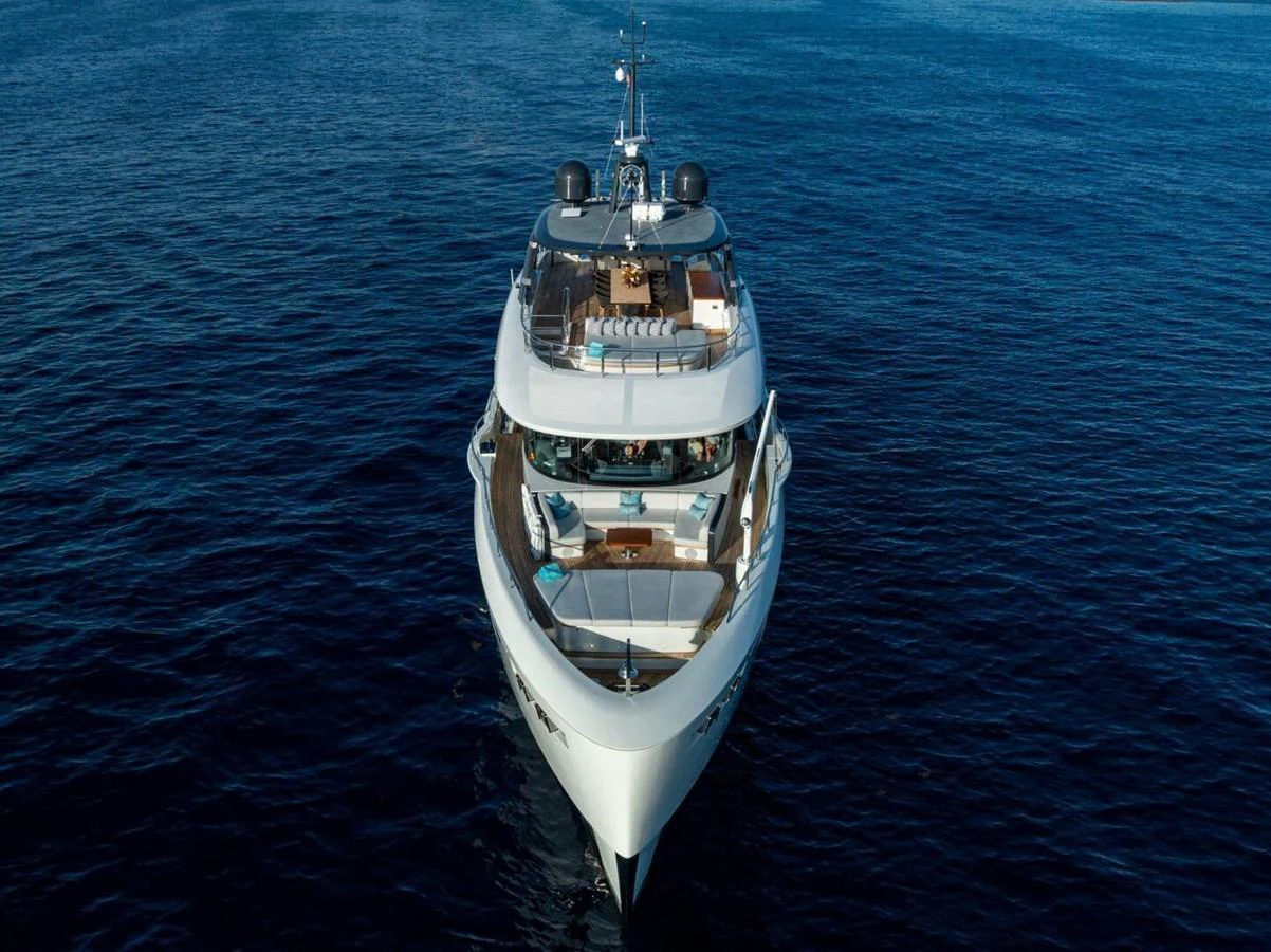 A luxurious yacht glides gracefully on calm blue waters, showcasing its sleek design and spacious decks. aboard KING'S LAIR Yacht for Sale