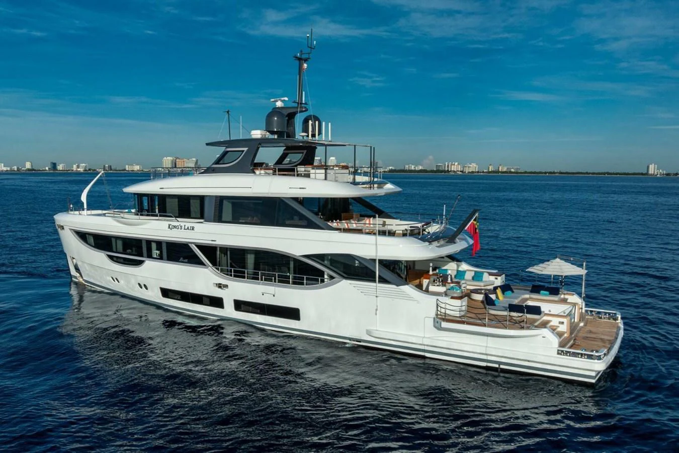 A luxurious yacht cruising on calm waters with a clear blue sky in the background. aboard KING'S LAIR Yacht for Sale