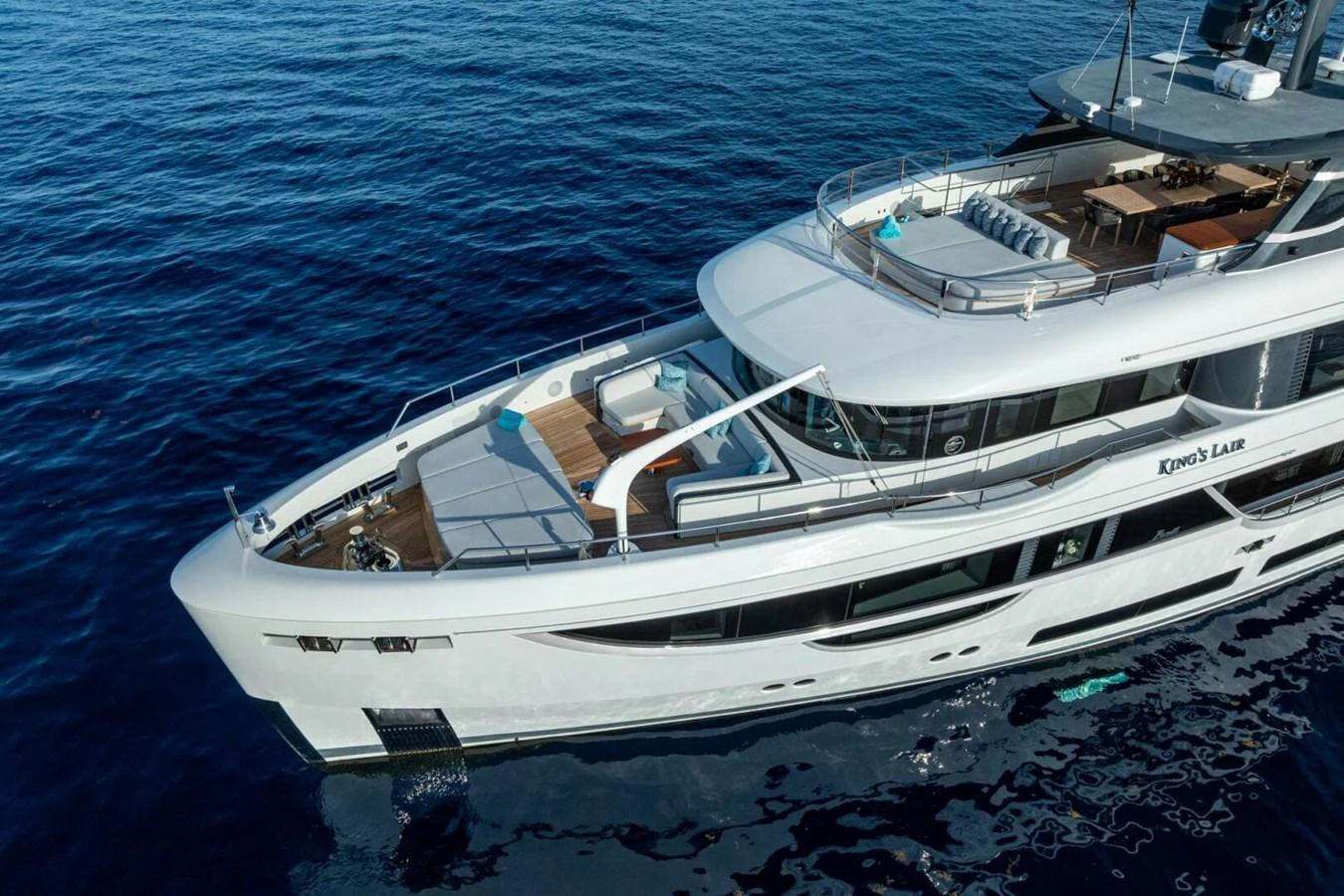 A luxurious yacht glides gracefully on the serene blue waters, showcasing its elegant design and spacious decks. aboard KING'S LAIR Yacht for Sale