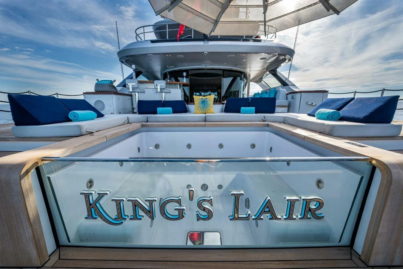The aft deck features a luxurious jacuzzi with plush seating and a view of the yacht's nameplate. aboard KING'S LAIR Yacht for Sale
