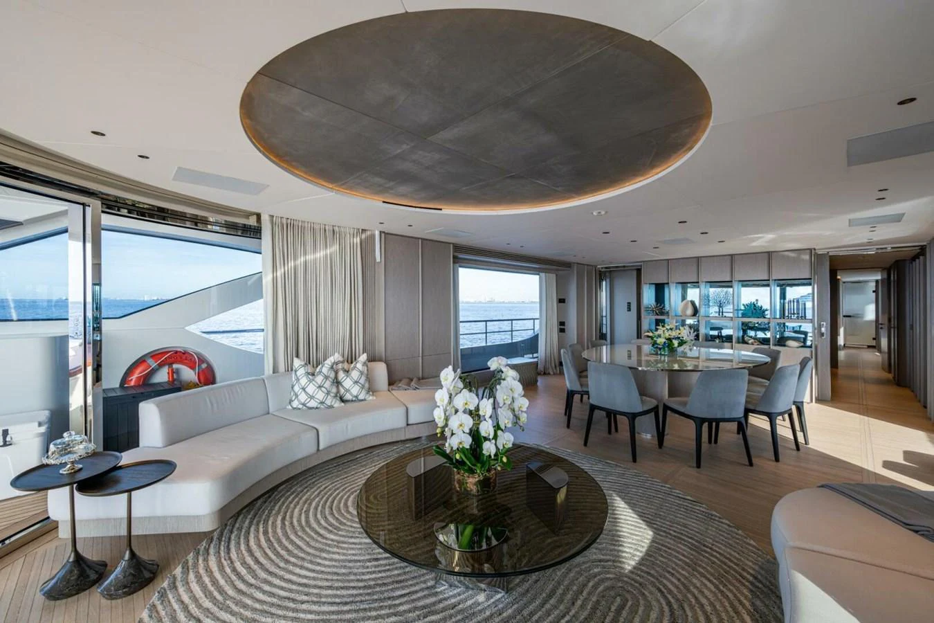 The spacious salon features elegant seating, a dining area, and panoramic views. aboard KING'S LAIR Yacht for Sale