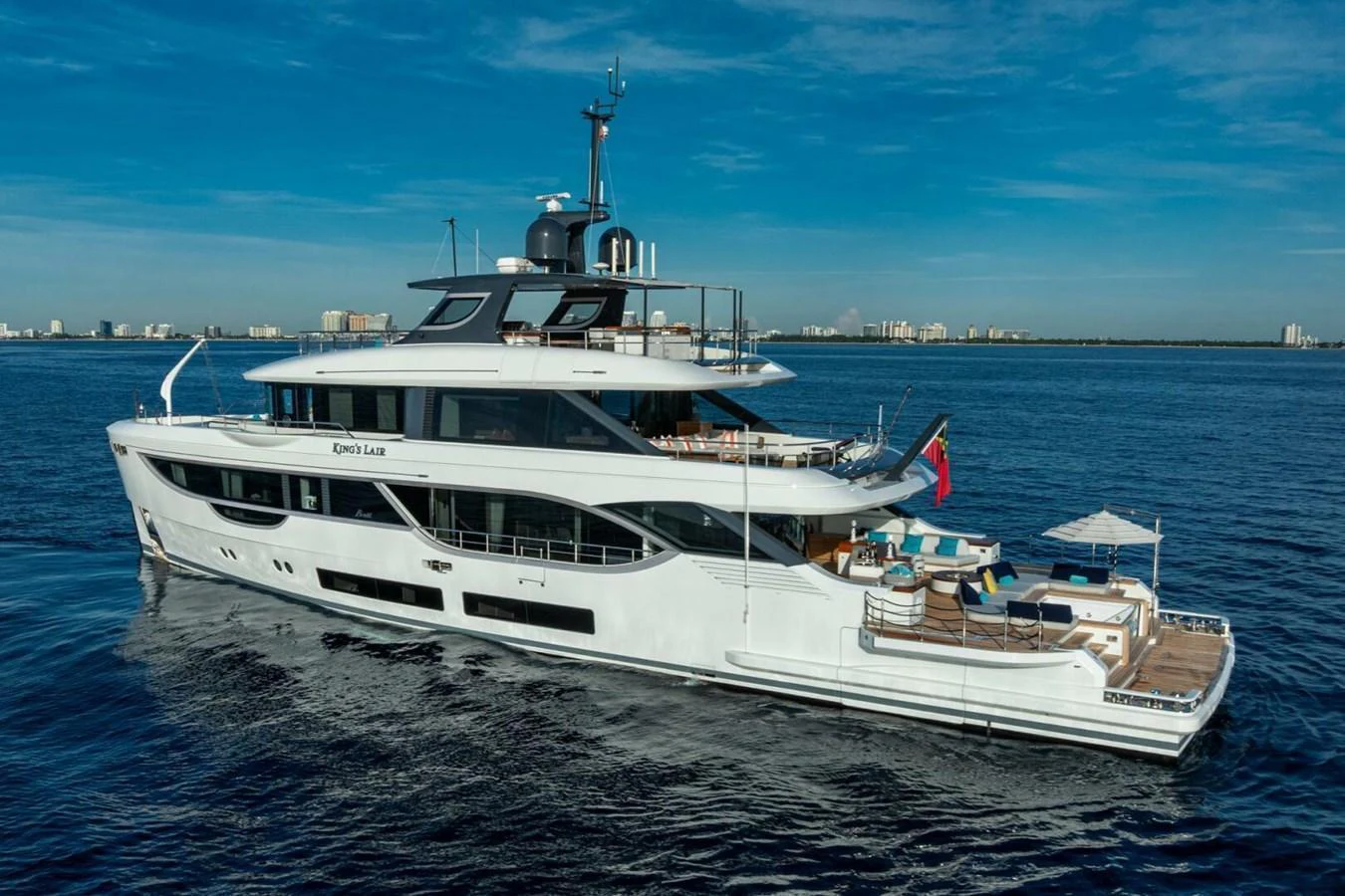 A luxurious yacht cruising on calm waters with a clear skyline in the background. aboard KING'S LAIR Yacht for Sale