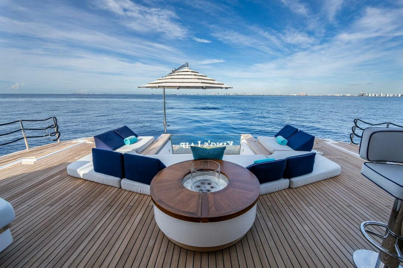 The aft deck features luxurious seating with a central fire pit and a stunning ocean view. aboard KING'S LAIR Yacht for Sale
