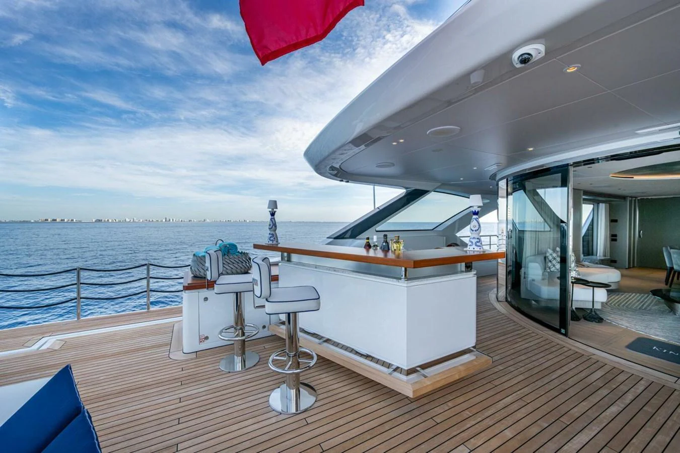 The aft deck features a stylish bar area with comfortable seating and a seamless transition to the interior. aboard KING'S LAIR Yacht for Sale