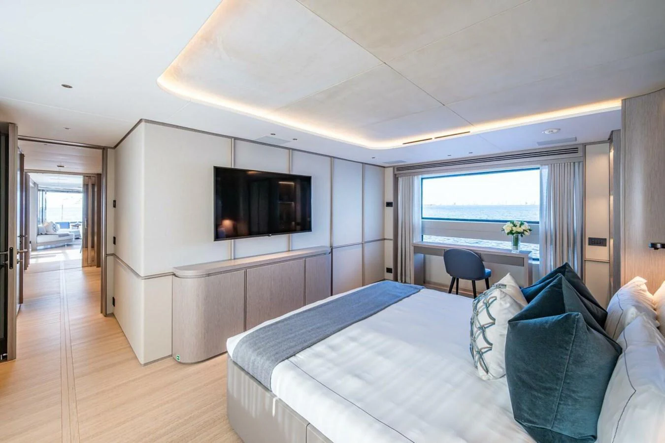 The master stateroom features a spacious layout with a large bed, modern furnishings, and a stunning view through the window. aboard KING'S LAIR Yacht for Sale