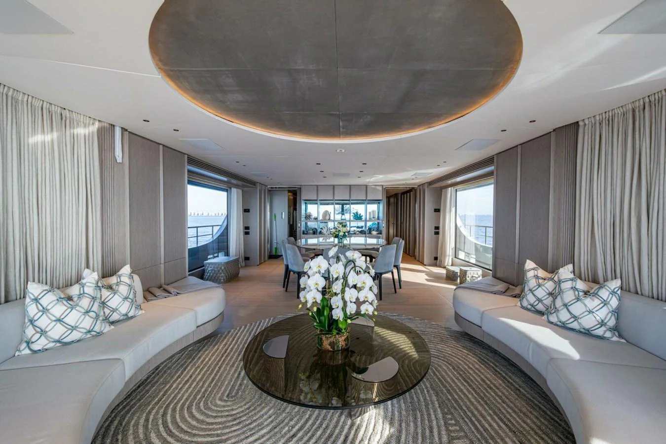The salon features elegant seating arrangements with a central glass table adorned with flowers, creating a luxurious and inviting atmosphere. aboard KING'S LAIR Yacht for Sale