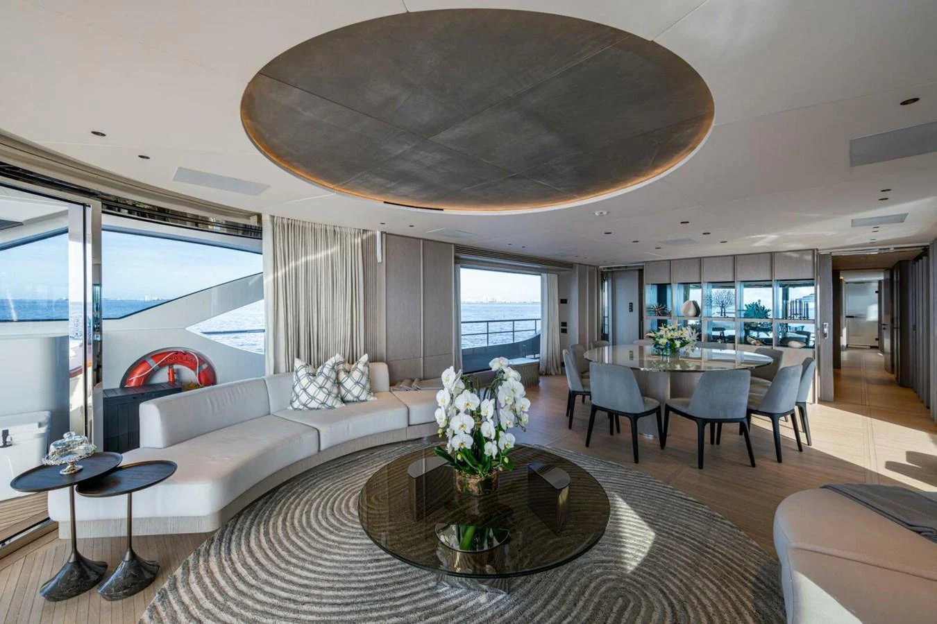 The spacious salon features elegant seating, a dining area, and large windows offering stunning ocean views. aboard KING'S LAIR Yacht for Sale
