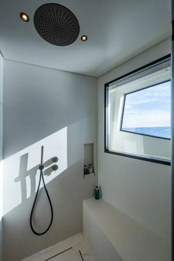 A sleek and modern yacht bathroom with a large window offering a view of the sea. aboard KING'S LAIR Yacht for Sale
