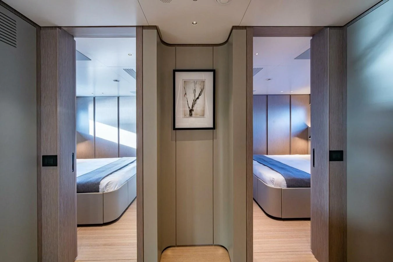 The image showcases the entrance to two elegant guest staterooms with modern decor and soft lighting. aboard KING'S LAIR Yacht for Sale