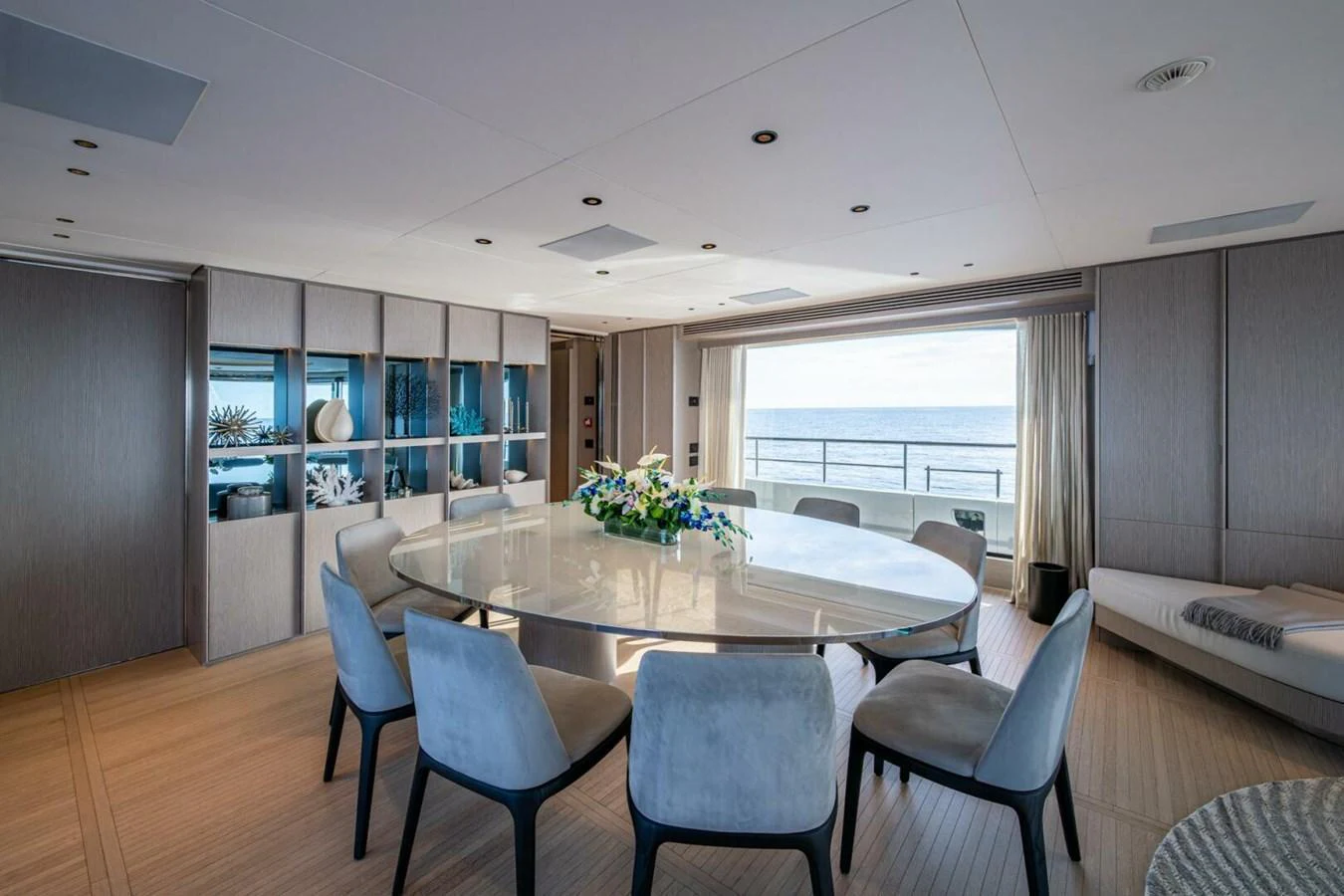 The yacht's dining area features a sleek, modern design with a large round table and comfortable seating, offering stunning ocean views. aboard KING'S LAIR Yacht for Sale