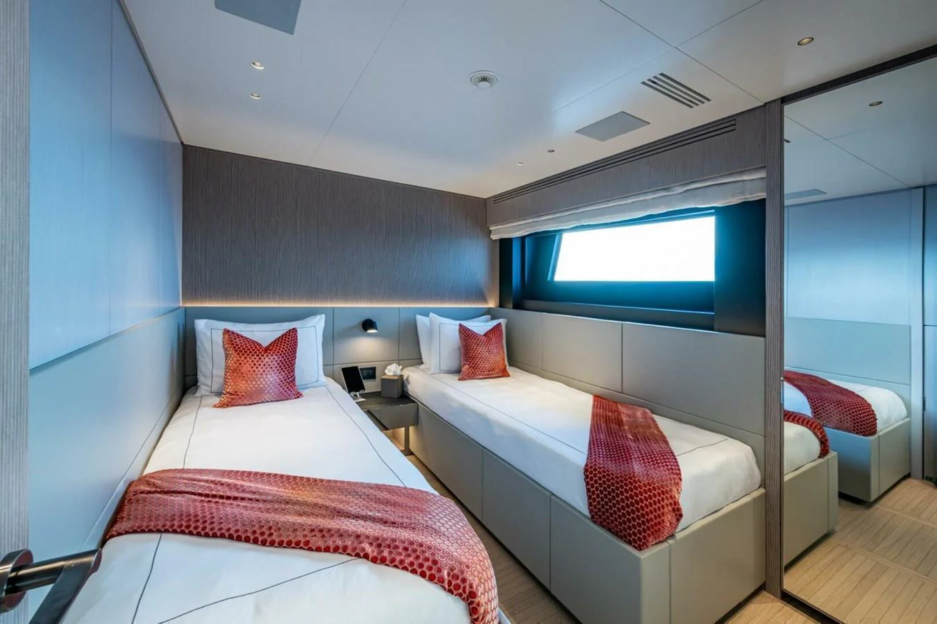 The guest stateroom features twin beds with modern decor and a large window for natural light. aboard KING'S LAIR Yacht for Sale