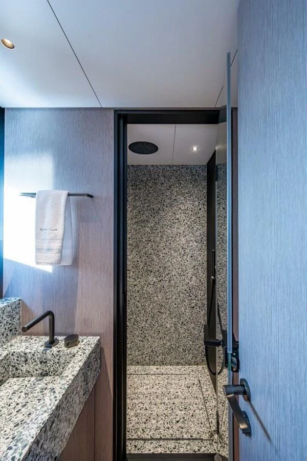 A sleek and modern yacht bathroom with a granite shower and stylish fixtures. aboard KING'S LAIR Yacht for Sale