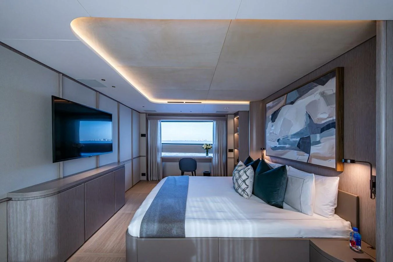 The master stateroom features a spacious bed, modern decor, and a large window with an ocean view. aboard KING'S LAIR Yacht for Sale