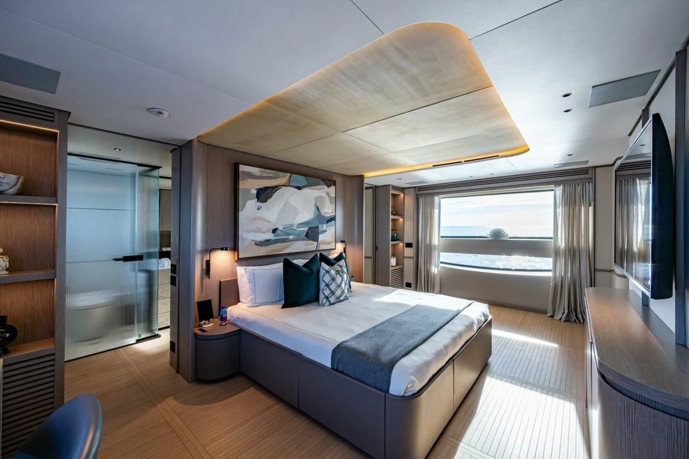 The master stateroom features a luxurious bed, modern decor, and a large window with a stunning view. aboard KING'S LAIR Yacht for Sale