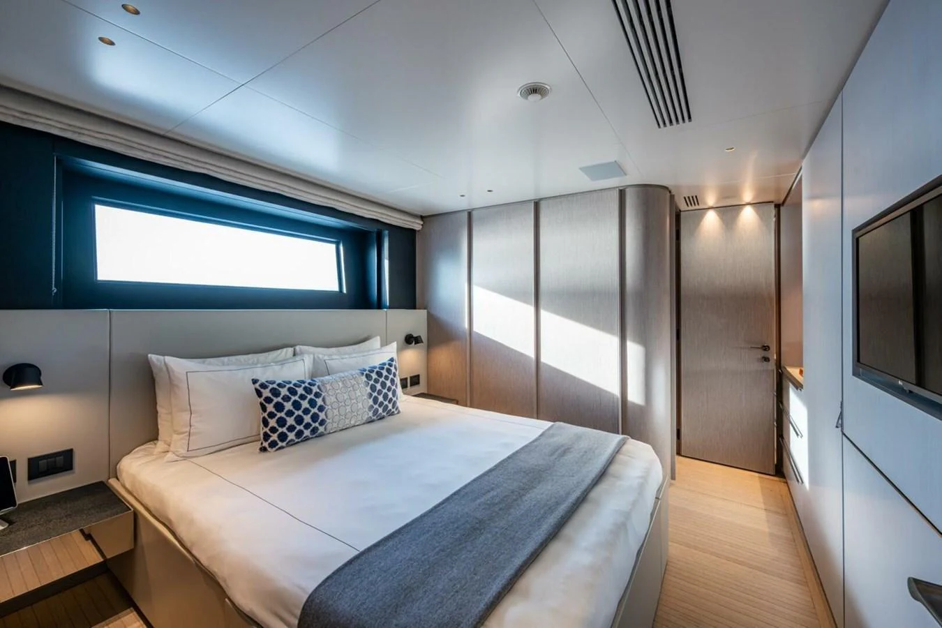 A luxurious stateroom featuring a large bed with elegant bedding and modern decor. aboard KING'S LAIR Yacht for Sale