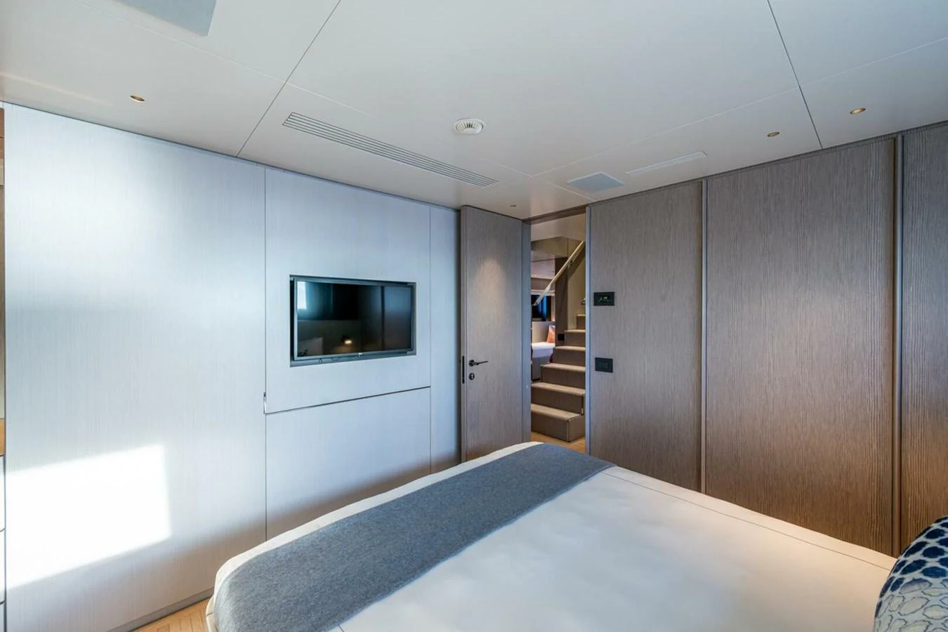 A luxurious stateroom featuring a large bed, modern decor, and a flat-screen TV. aboard KING'S LAIR Yacht for Sale