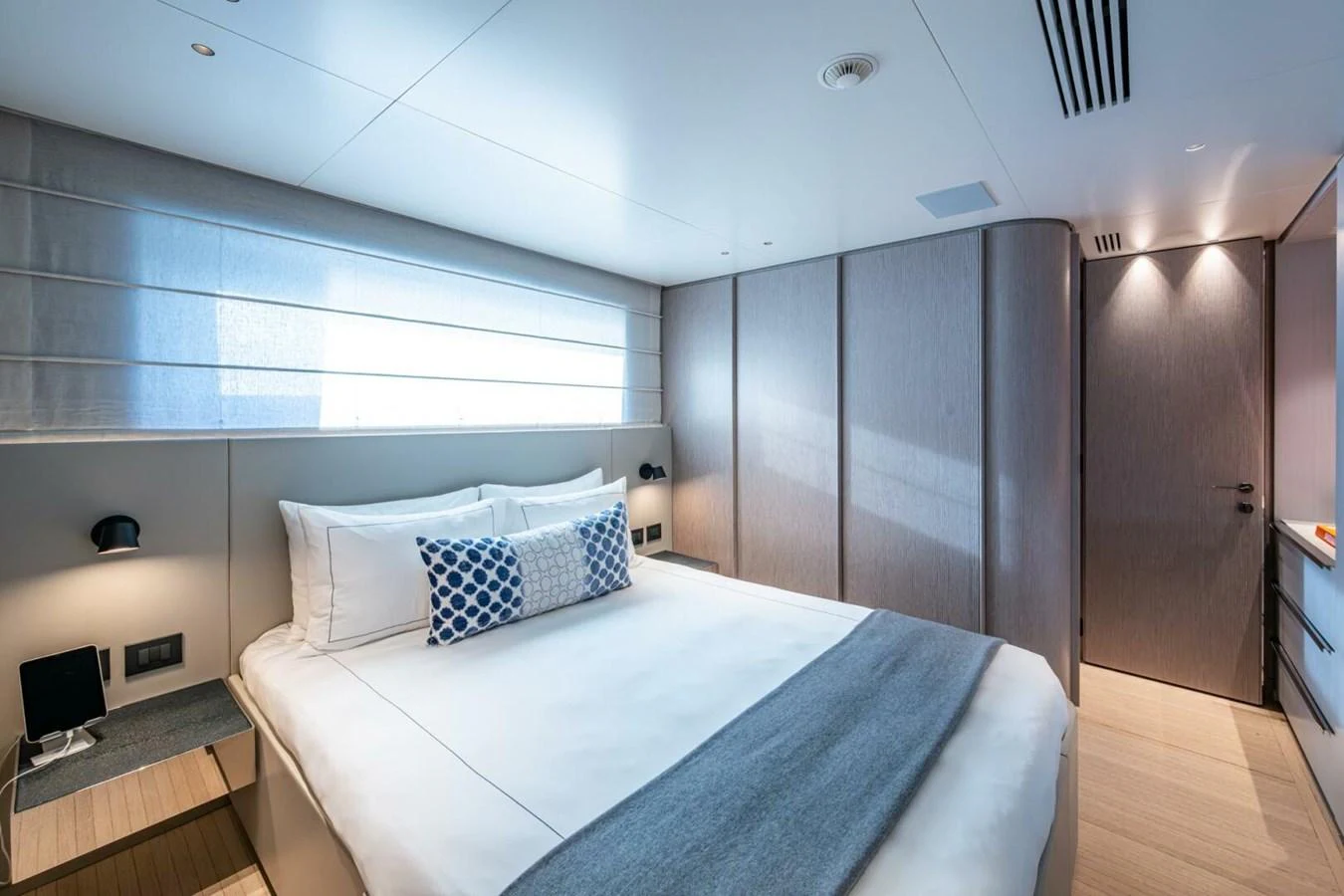 The stateroom features a spacious bed with modern decor and ample natural light. aboard KING'S LAIR Yacht for Sale