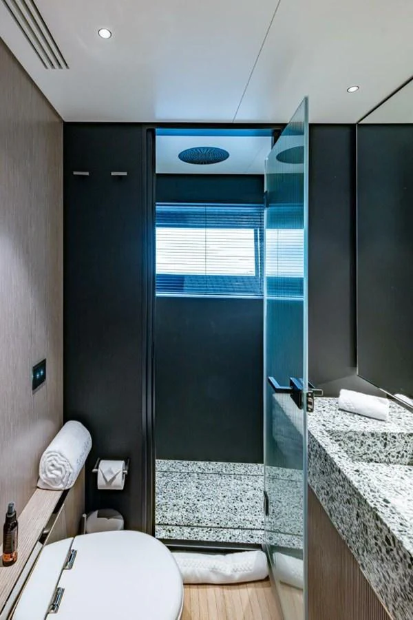 A sleek and modern yacht bathroom with a glass shower and elegant fixtures. aboard KING'S LAIR Yacht for Sale