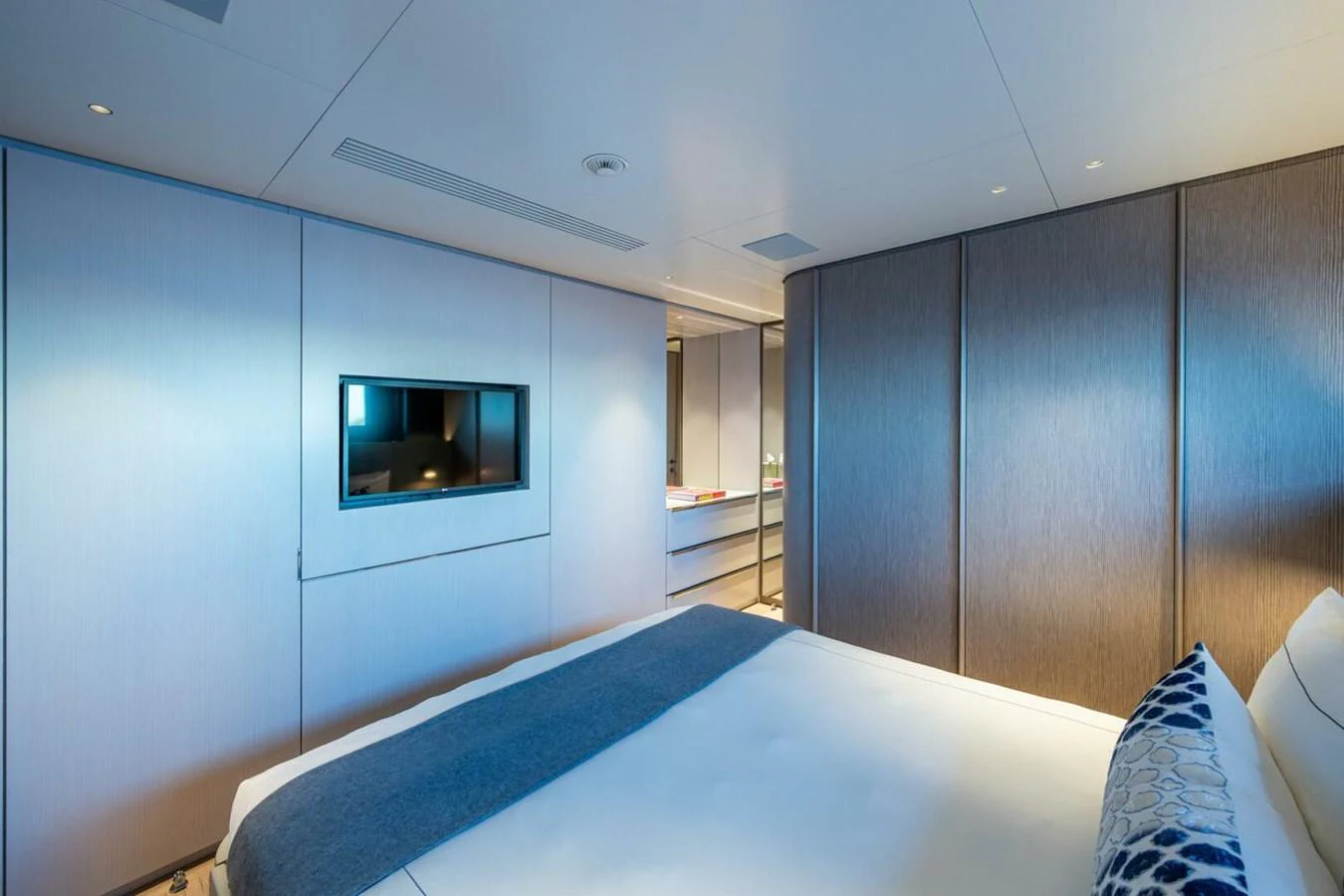 The stateroom features a modern design with a large bed and built-in entertainment system. aboard KING'S LAIR Yacht for Sale