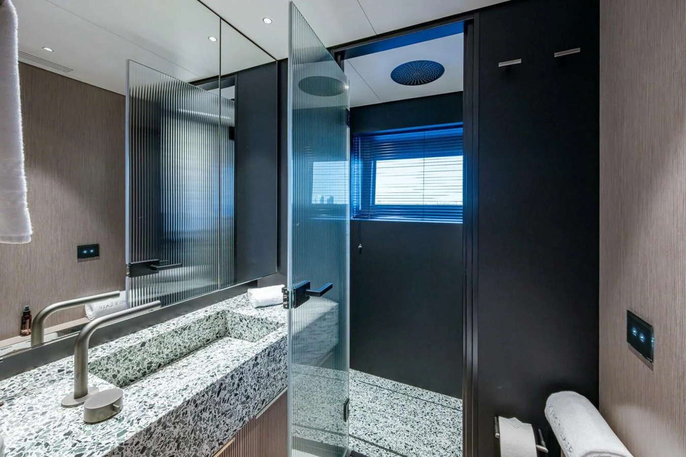 A sleek and modern bathroom with a granite countertop and glass shower enclosure. aboard KING'S LAIR Yacht for Sale