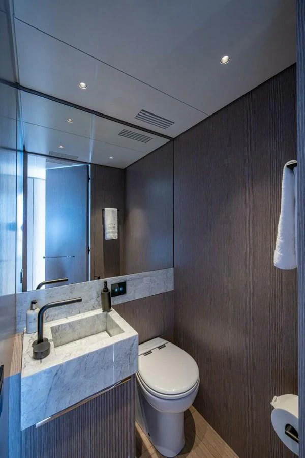 A sleek and modern yacht bathroom featuring a marble sink and contemporary fixtures. aboard KING'S LAIR Yacht for Sale