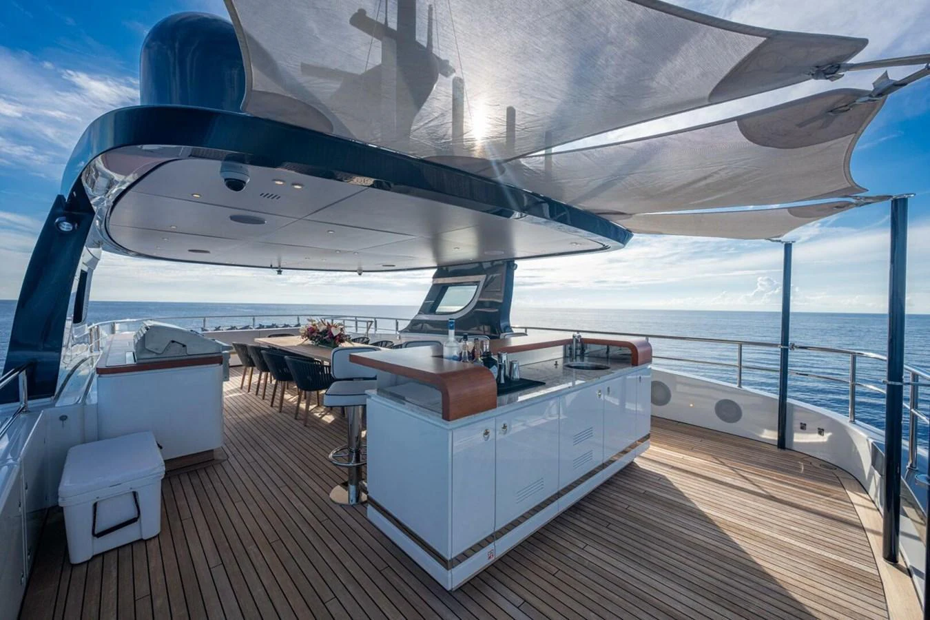 The flybridge offers a spacious and luxurious outdoor area with a bar and ample seating under a stylish canopy. aboard KING'S LAIR Yacht for Sale