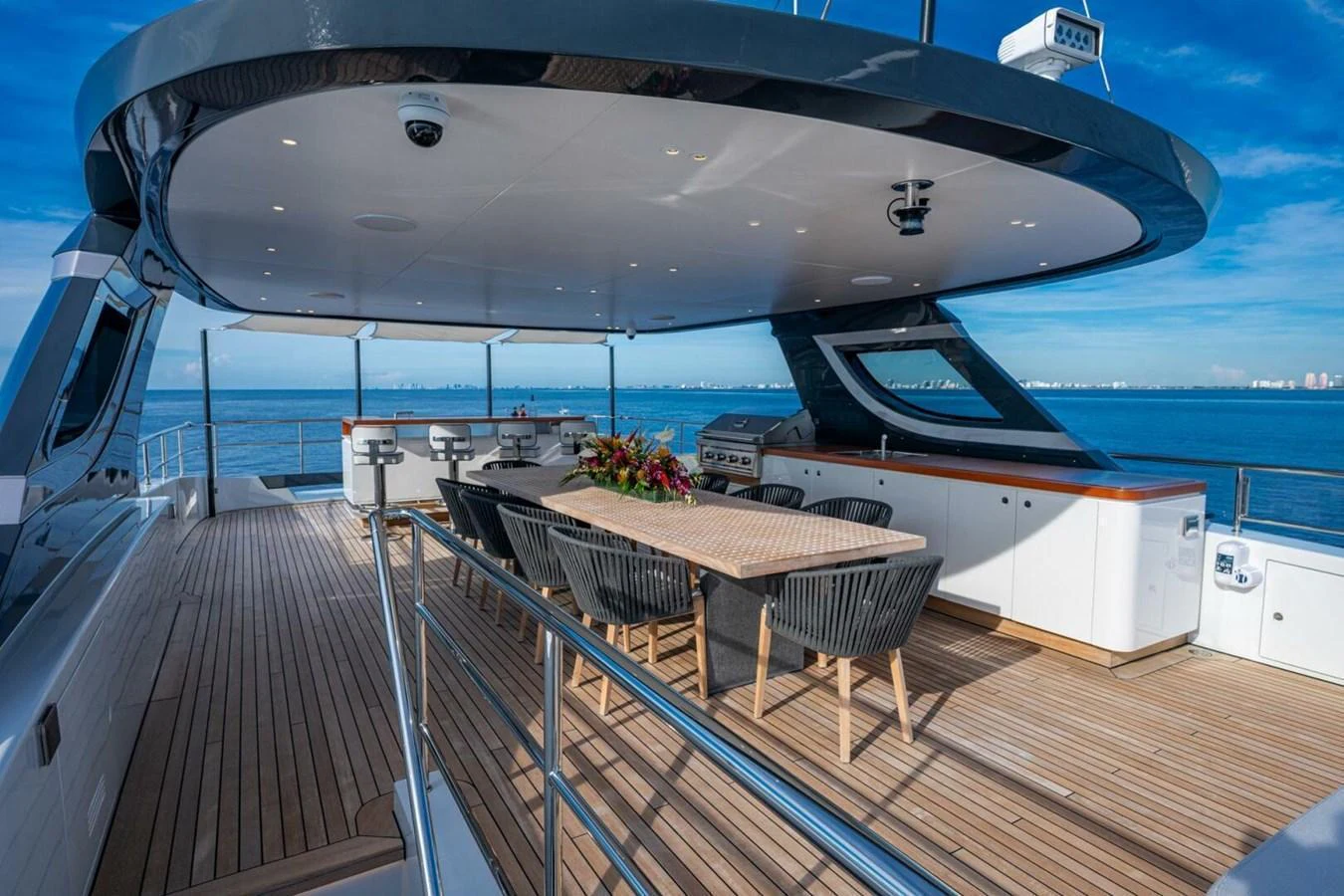 The yacht's aft deck features a spacious dining area with a stunning ocean view. aboard KING'S LAIR Yacht for Sale