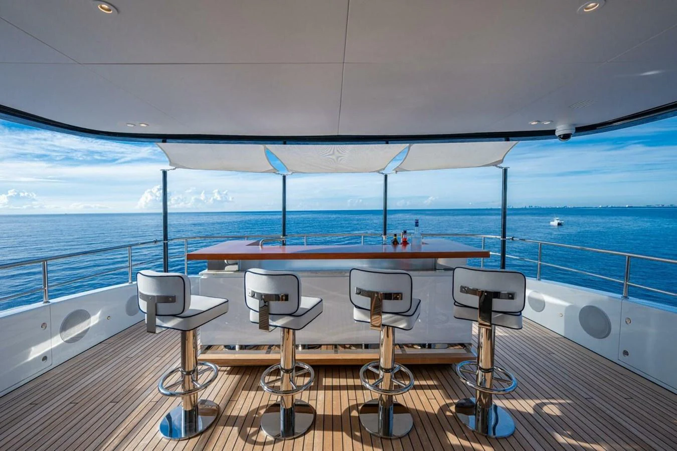 The yacht features a stylish bar area with modern stools and panoramic ocean views. aboard KING'S LAIR Yacht for Sale