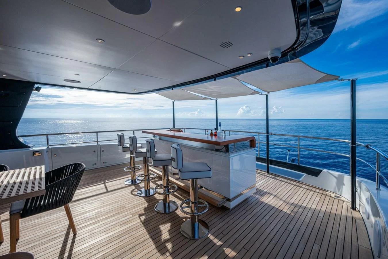 The aft deck features a stylish bar area with stunning ocean views. aboard KING'S LAIR Yacht for Sale