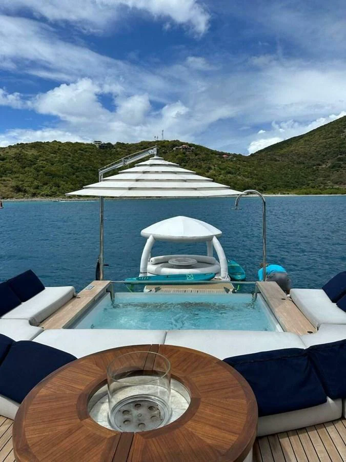 The sundeck features a luxurious jacuzzi surrounded by comfortable seating, offering stunning views of the water and landscape. aboard KING'S LAIR Yacht for Sale