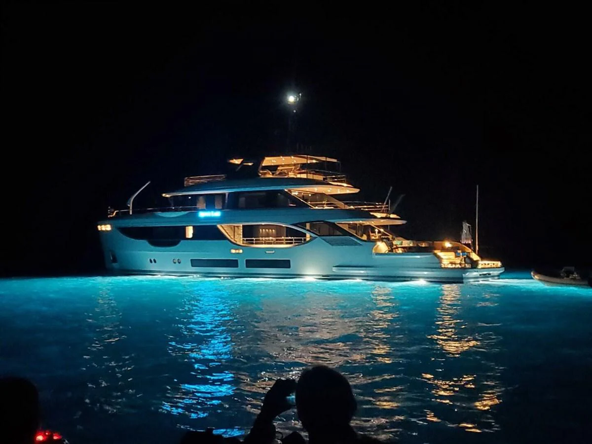 A stunning yacht illuminated at night, showcasing its elegant design and glowing presence on the water. aboard KING'S LAIR Yacht for Sale