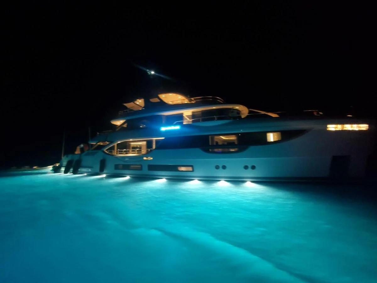 A stunning yacht illuminated at night, showcasing its sleek design and underwater lights. aboard KING'S LAIR Yacht for Sale