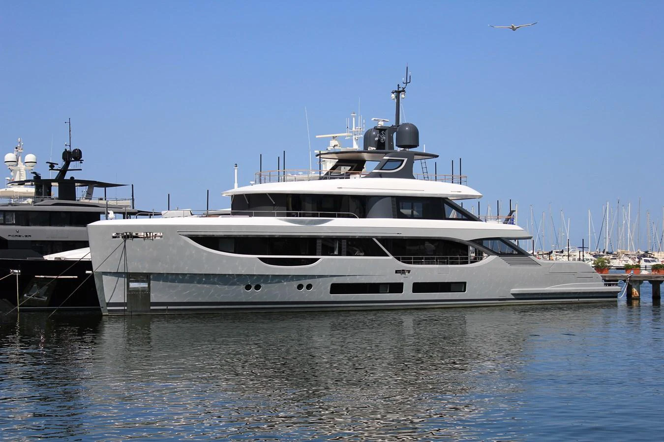 A sleek and modern yacht docked at a marina, showcasing its elegant design and spacious decks. aboard OASIS 34M BO212 Yacht for Sale
