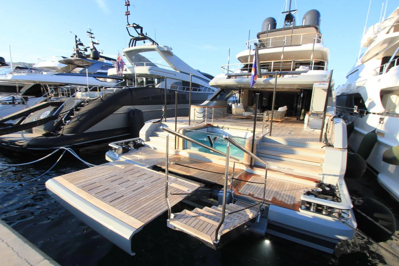 The yacht's aft deck features a luxurious lounging area with a built-in jacuzzi and elegant wooden decking. aboard OASIS 34M BO212 Yacht for Sale