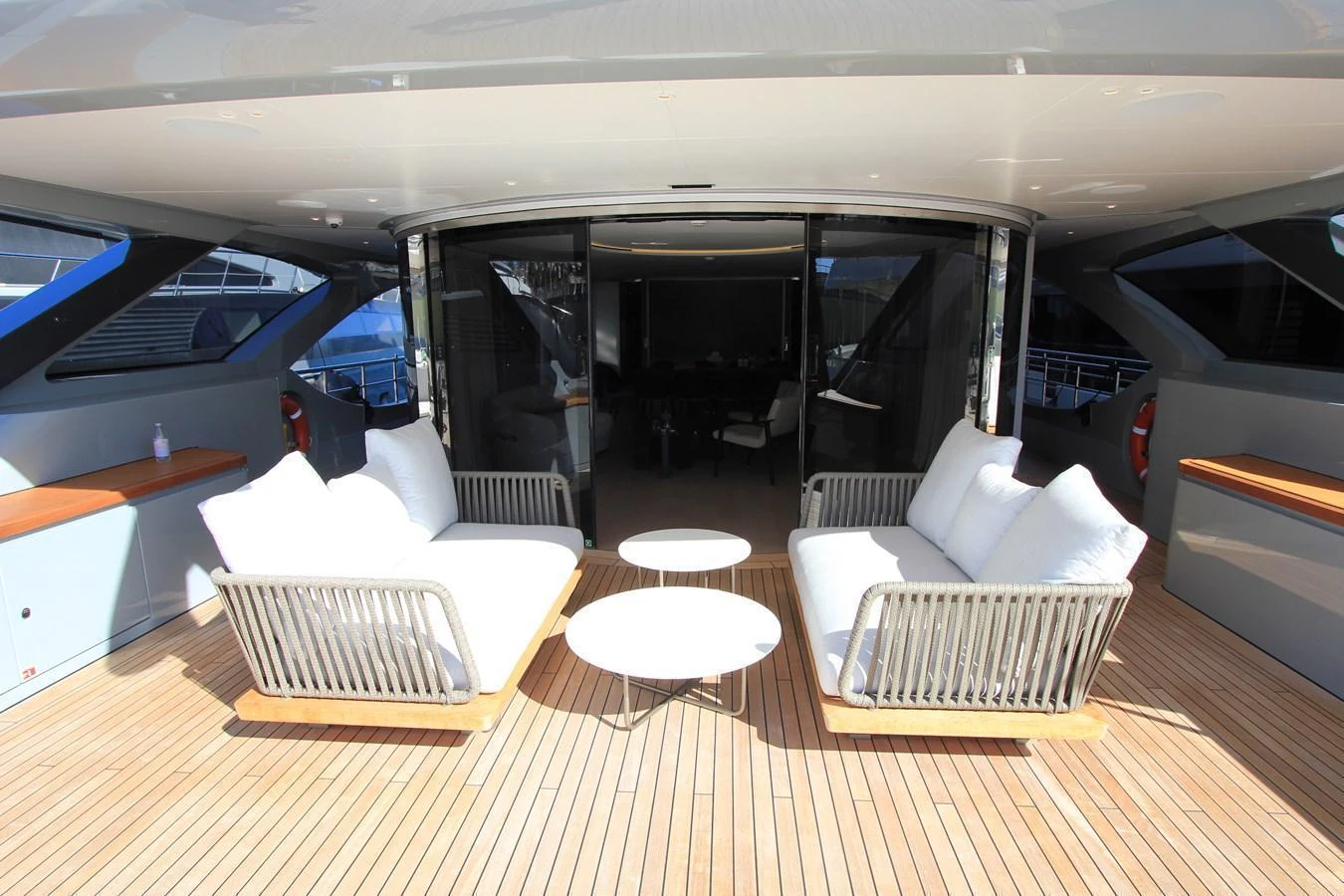 The aft deck features a stylish seating area with plush white cushions and a sleek wooden deck. aboard OASIS 34M BO212 Yacht for Sale