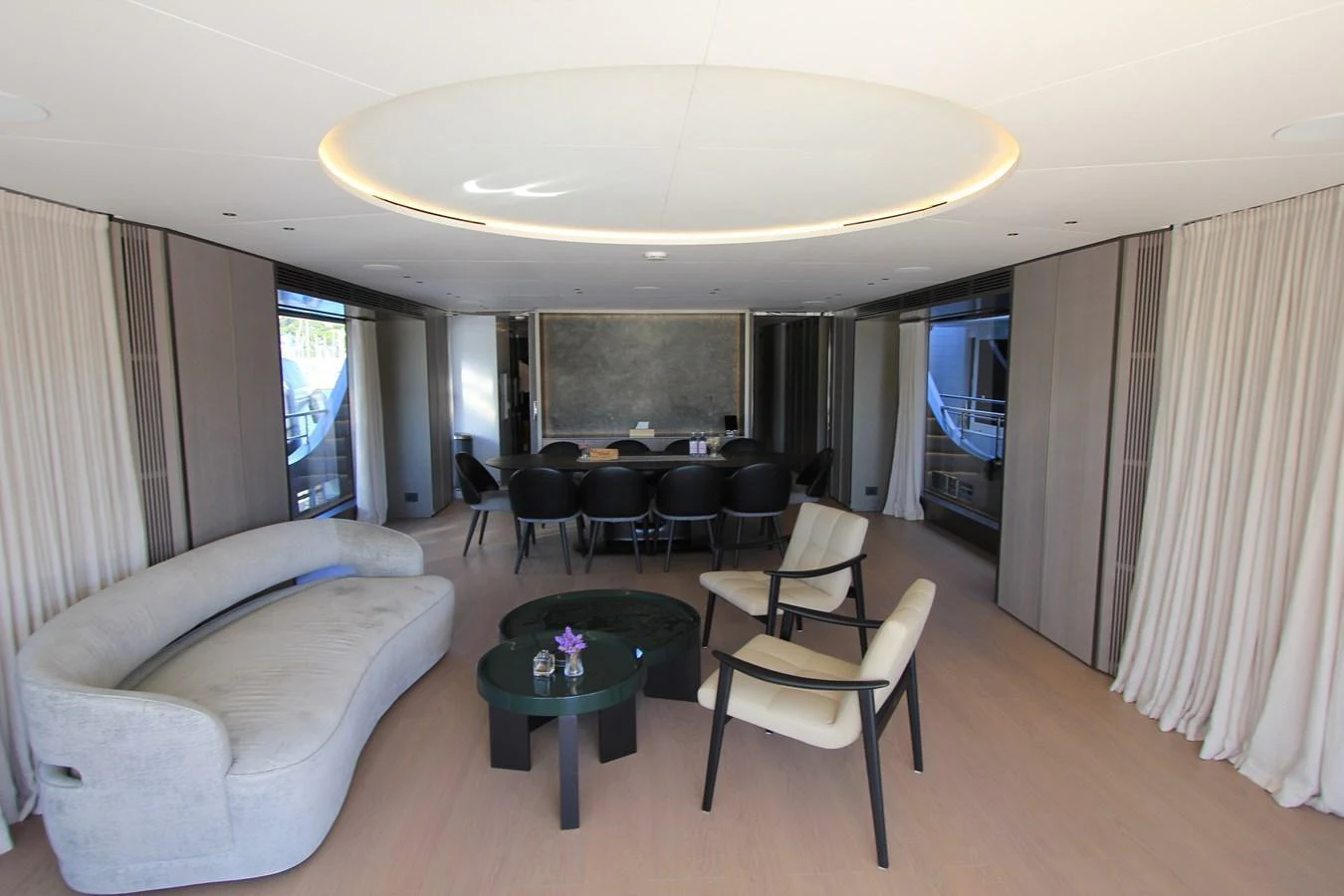 A sophisticated and modern interior lounge area with comfortable seating and a large dining table. aboard OASIS 34M BO212 Yacht for Sale