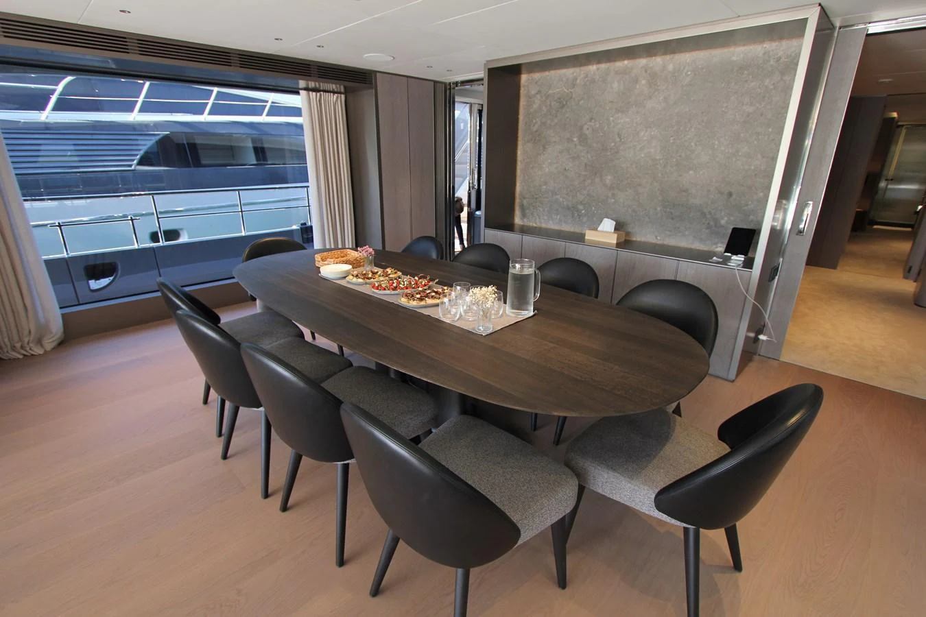 The yacht's dining area features a sleek table with comfortable seating and a modern design. aboard OASIS 34M BO212 Yacht for Sale