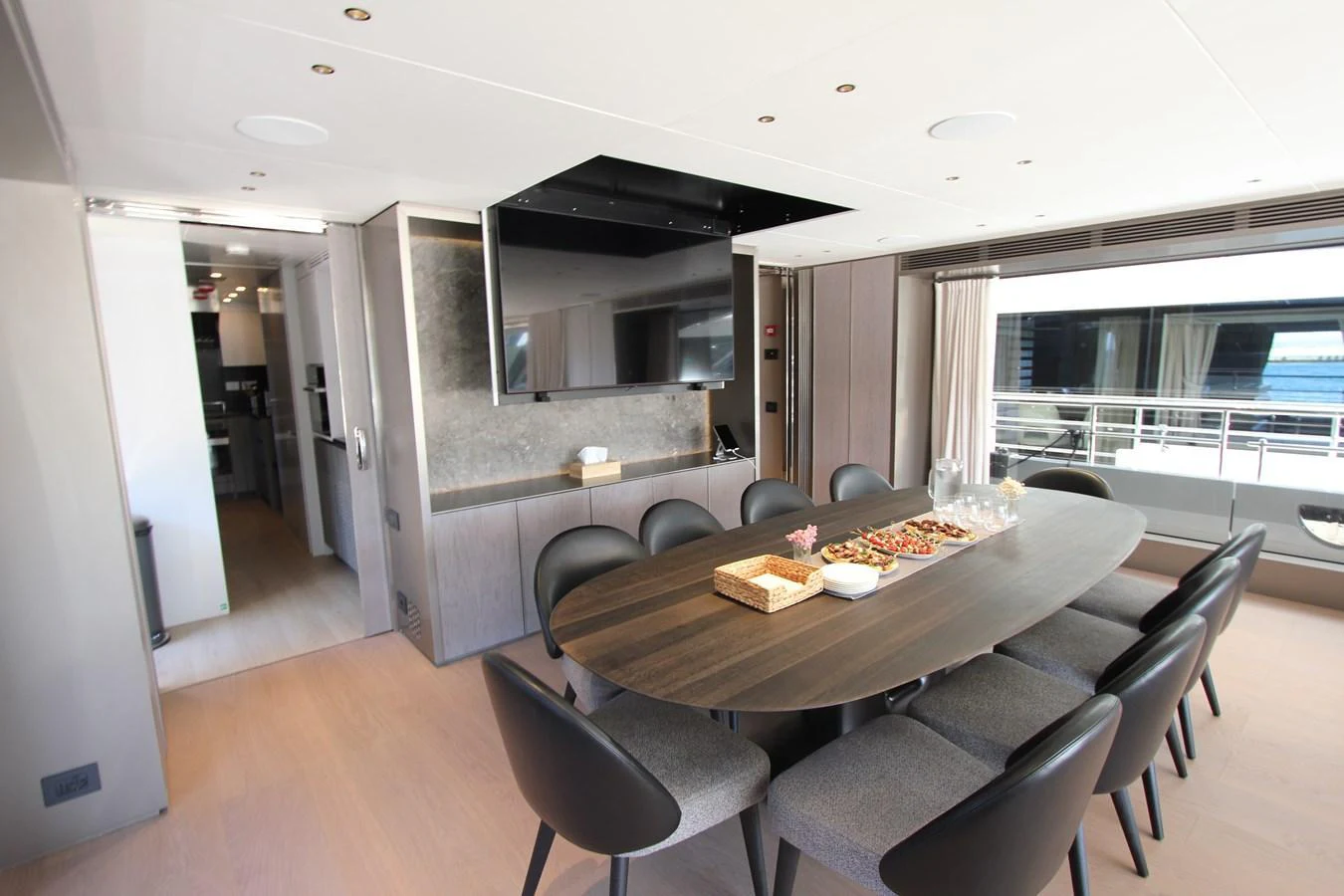 The yacht's dining area features a sleek table surrounded by comfortable chairs, perfect for elegant meals. aboard OASIS 34M BO212 Yacht for Sale