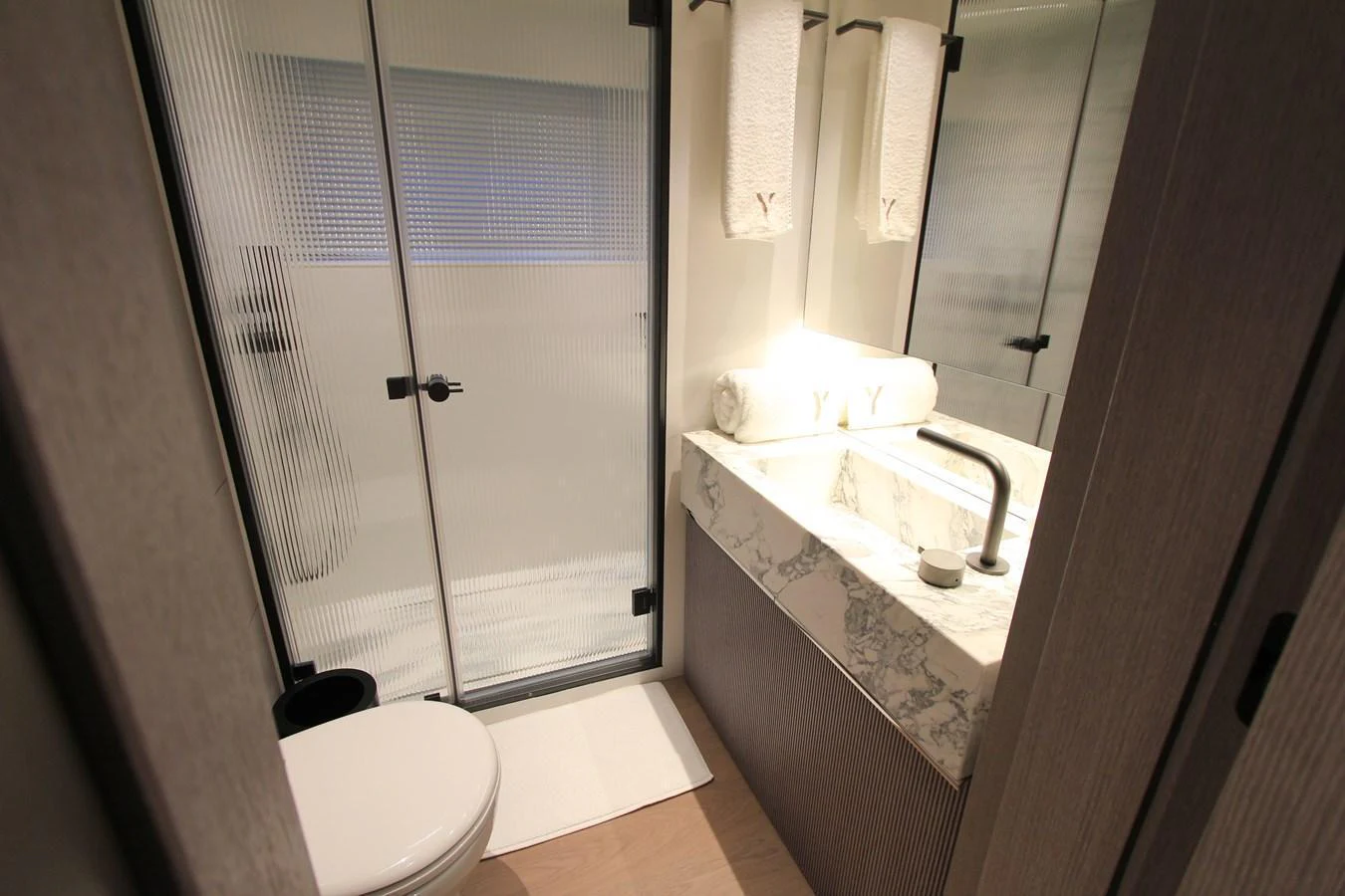 The yacht's bathroom features a sleek and modern design with a marble countertop and glass shower enclosure. aboard OASIS 34M BO212 Yacht for Sale