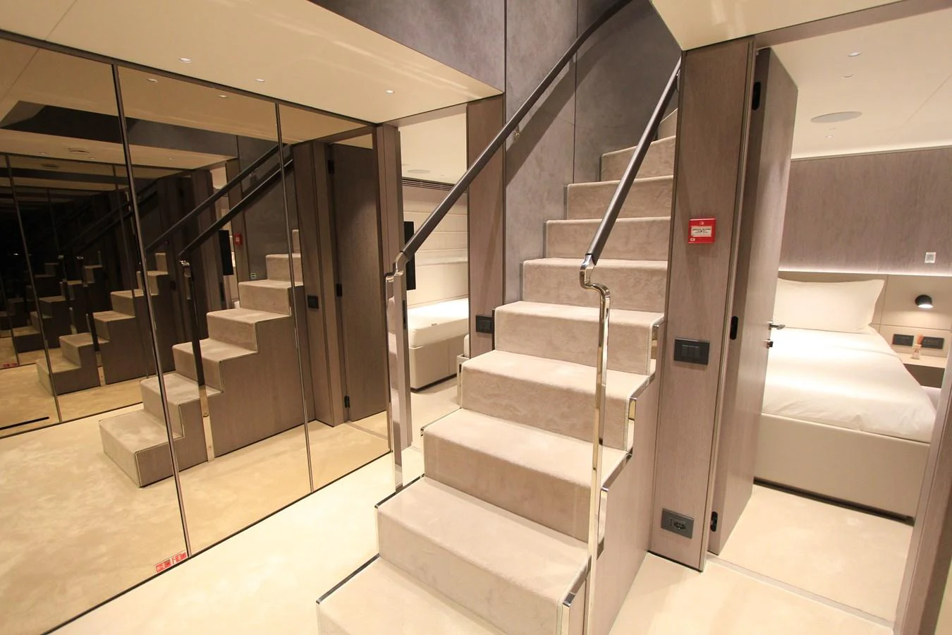 The luxurious stateroom features a modern staircase leading to an upper level, with mirrored walls enhancing the spacious feel. aboard OASIS 34M BO212 Yacht for Sale
