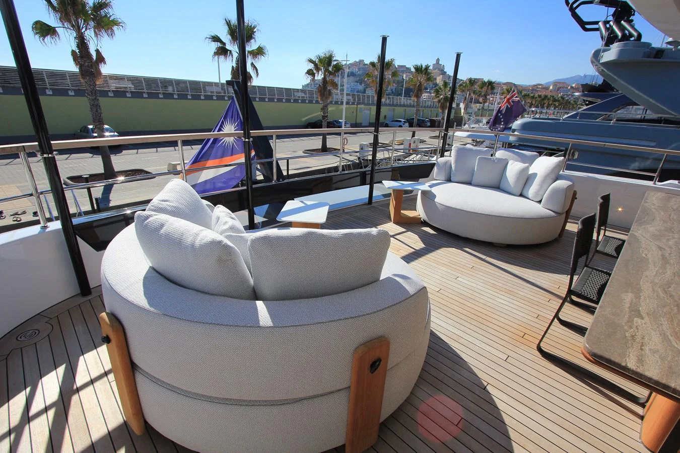 The aft deck features luxurious circular seating with a stunning view of the marina. aboard OASIS 34M BO212 Yacht for Sale