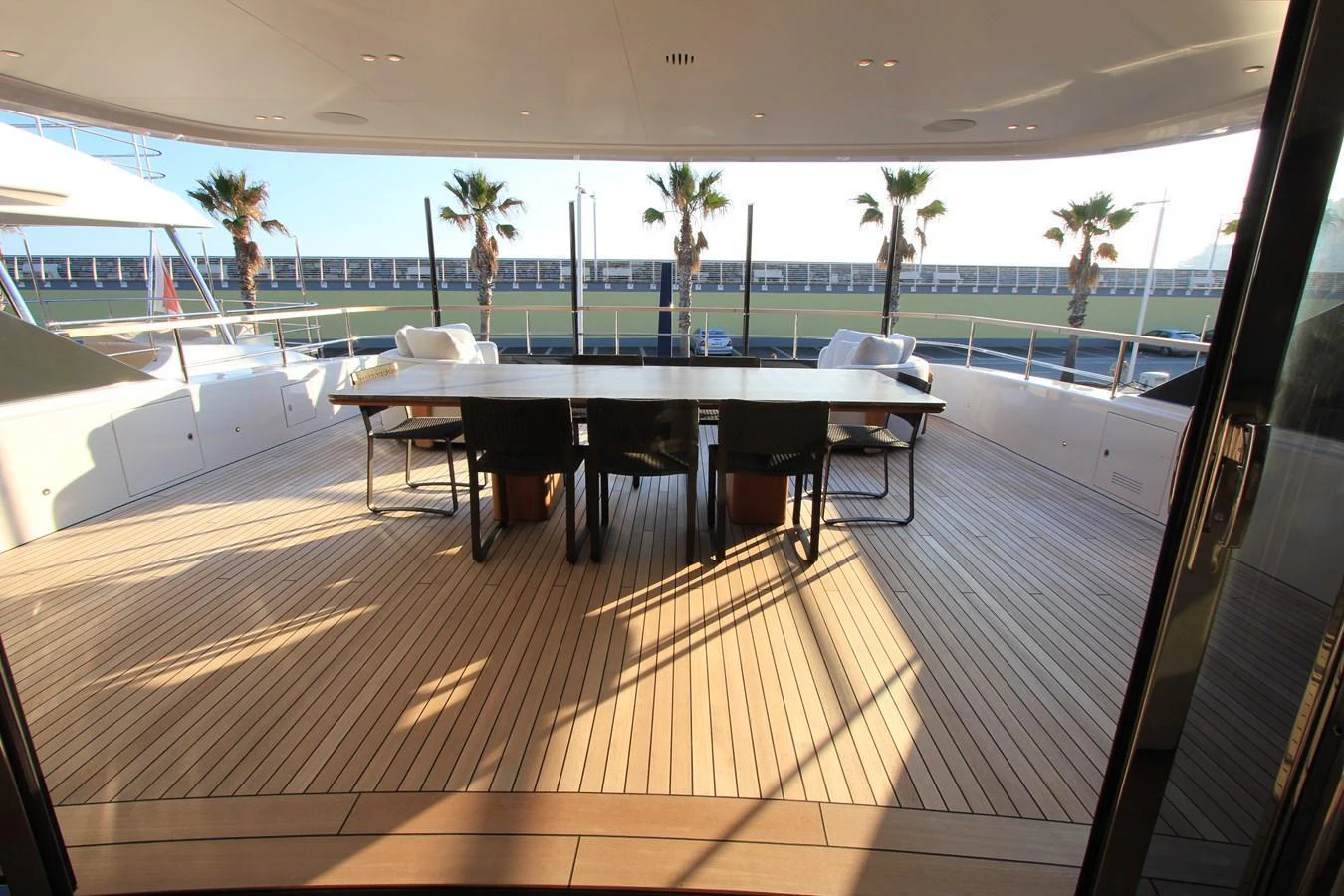 The aft deck features a spacious dining area with a large table and comfortable seating, perfect for al fresco meals. aboard OASIS 34M BO212 Yacht for Sale