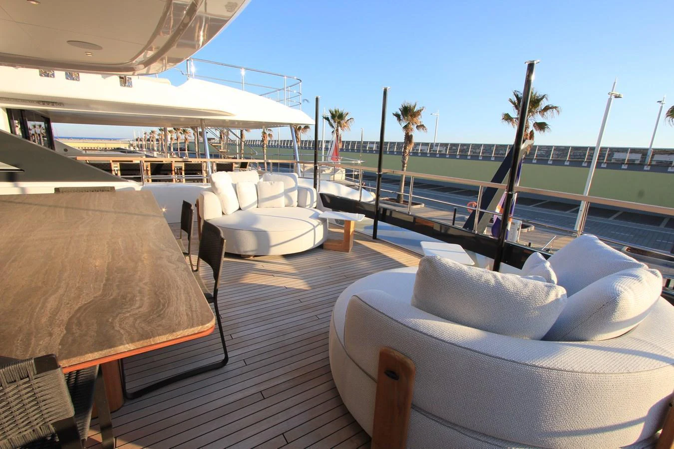 The aft deck features luxurious seating and a large dining table, perfect for outdoor relaxation and dining. aboard OASIS 34M BO212 Yacht for Sale