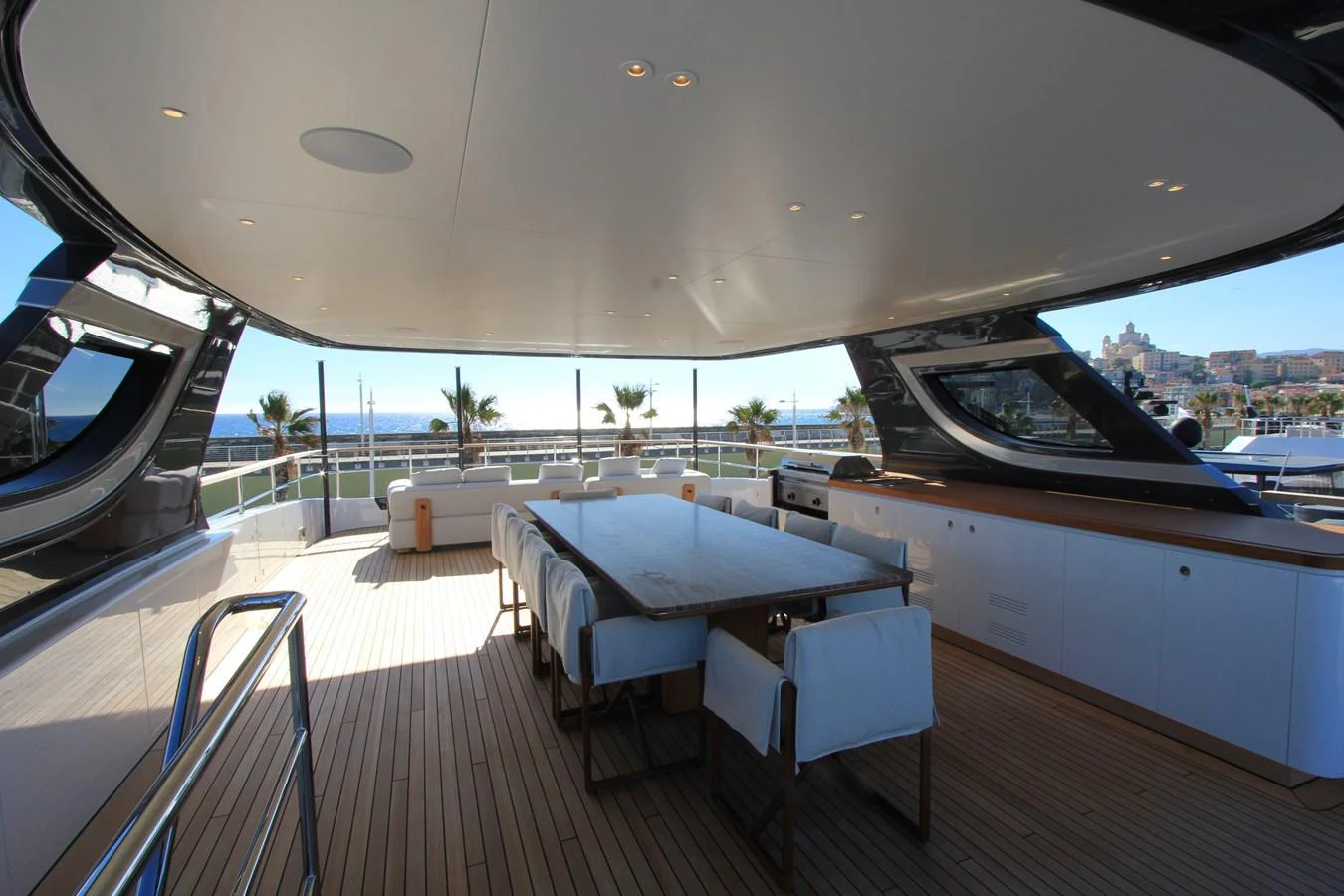 The aft deck features a spacious dining area with a large table and comfortable seating, perfect for alfresco dining. aboard OASIS 34M BO212 Yacht for Sale