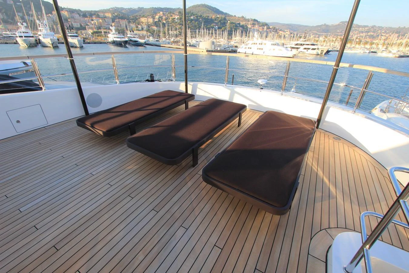The sundeck offers a serene space with three sun loungers, perfect for relaxation while enjoying the scenic marina views. aboard OASIS 34M BO212 Yacht for Sale
