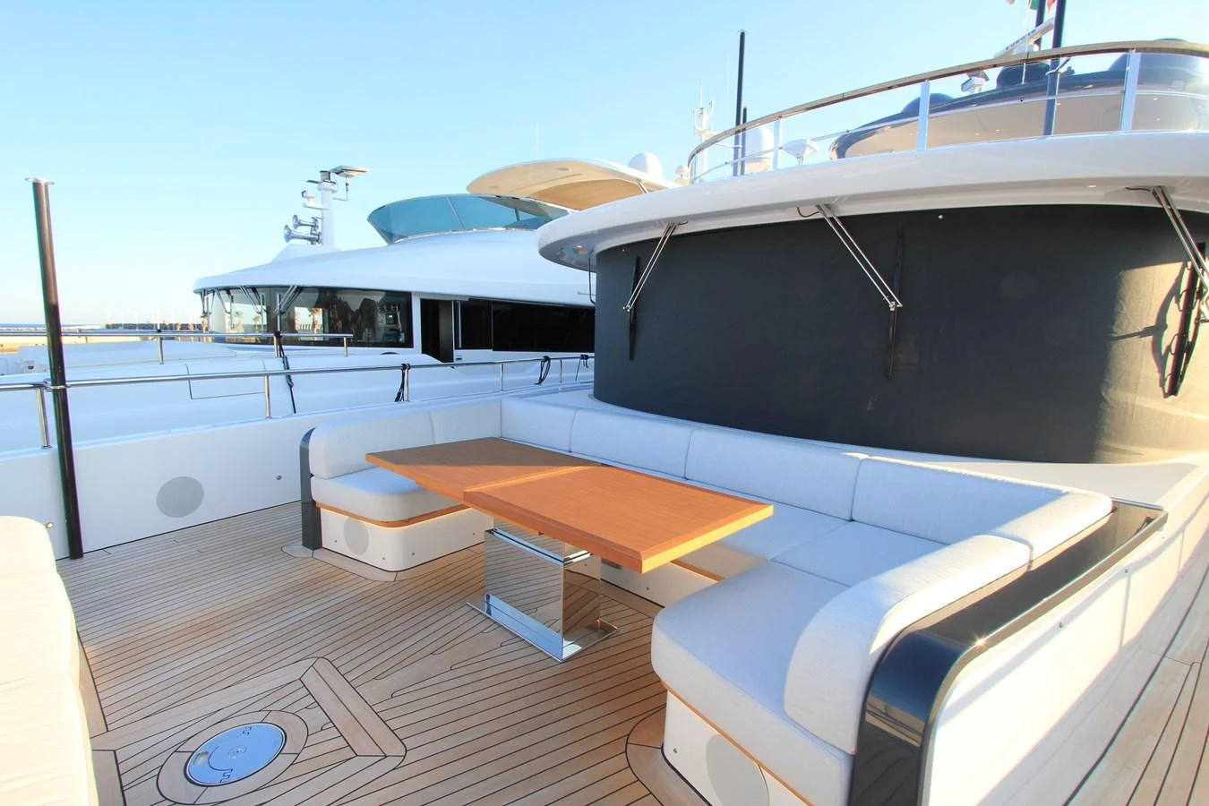The aft deck features a spacious seating area with a wooden table, perfect for outdoor relaxation. aboard OASIS 34M BO212 Yacht for Sale